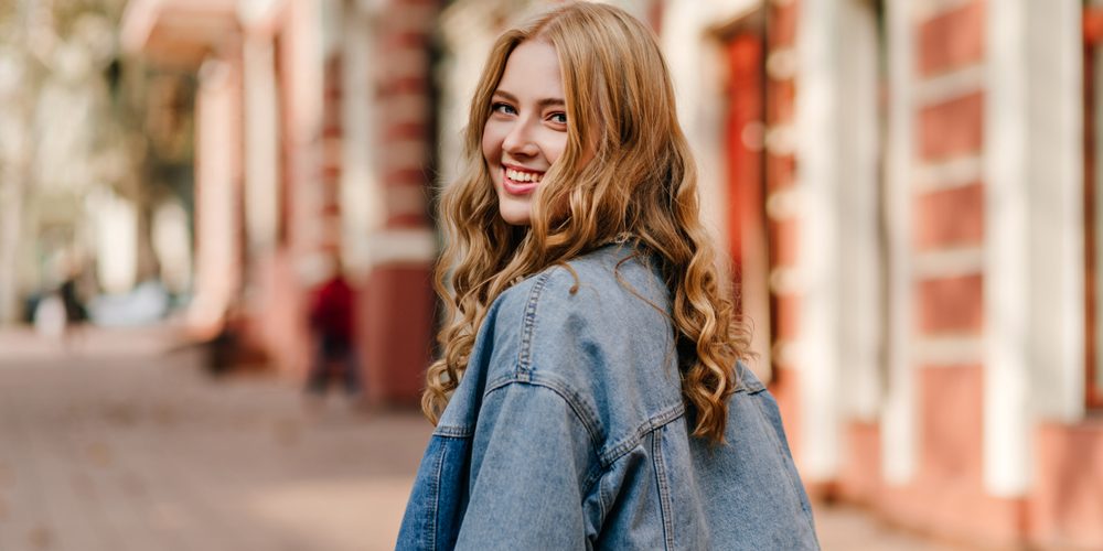 Portrait,Of,A,Blonde,Curly,Haired,Woman,Walking,On,The general dentist boston