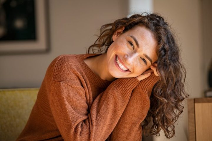 Happy,Young,Woman,Sitting,On,Sofa,At,Home,And,Looking dentist chelsea