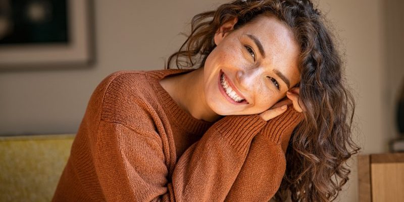 Happy,Young,Woman,Sitting,On,Sofa,At,Home,And,Looking dentist chelsea
